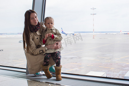航空母摄影照片_母亲和小女儿在机场航站楼望着窗外