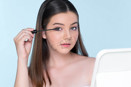 年轻迷人的特写肖像应用化妆眼影刷。