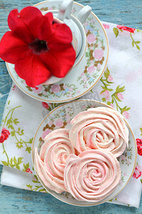 以玫瑰为形式的蛋白甜饼蛋糕，在一道带红花的浪漫菜肴中