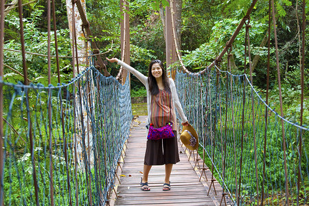 树林里木吊桥上的少女