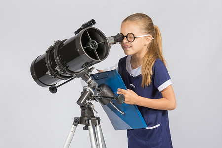 年轻的天文学家高兴地通过望远镜记录观察结果