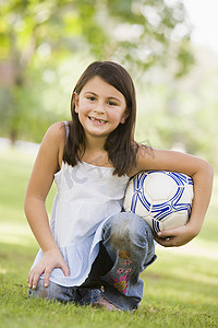 小学体育锻炼摄影照片_户外公园里的小女孩拿着球微笑