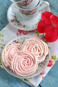 以玫瑰为形式的蛋白甜饼蛋糕，在一道带红花的浪漫菜肴中