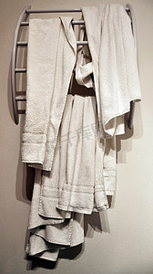 酒店浴室摄影照片_现代架子上用过的酒店毛巾