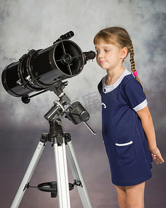 目镜摄影照片_天文爱好者感兴趣地看着望远镜的目镜