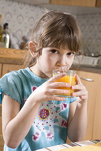 可爱严肃的七岁女孩喝橙汁