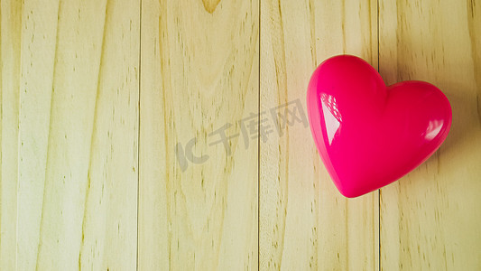 木桌上的粉红心，用于健康和医疗内容。