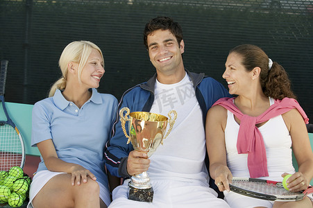 女人和男人拿着网球奖杯