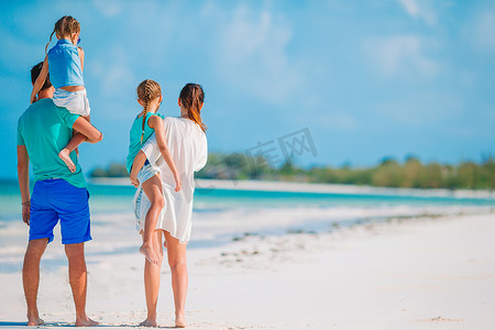 幸福的家庭在海滩上玩耍的照片。