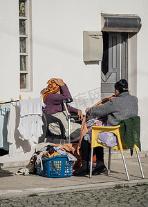 祖母或管家在阳光明媚的日子里在户外洗衣服