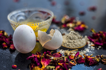 线条美学摄影照片_玻璃碗中木质表面的鸡蛋和贝桑或鹰嘴豆粉或克面粉，以及表面的生鸡蛋和面粉。用于治疗细纹和皱纹。