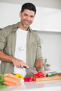 微笑的男人在厨房切菜