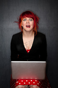 带笔记本电脑的红头发朋克女孩