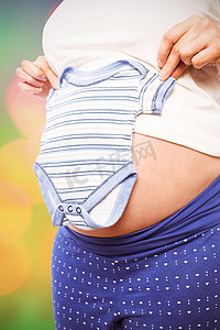 孕妇拿着婴儿衣服的合成图像