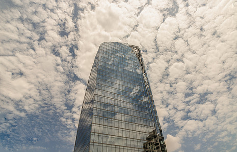 具有重复结构的现代高层建筑玻璃墙上的天空和建筑反射。
