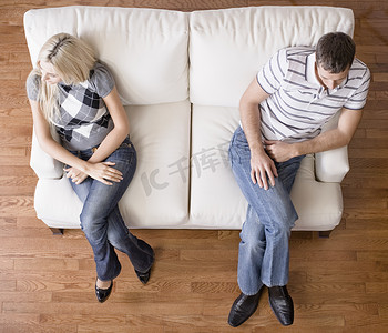 坐在双人沙发上的年轻夫妇
