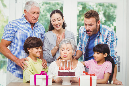 70年代的人摄影照片_奶奶和家人一起吹生日蜡烛