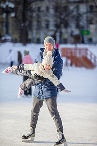 父子一家在户外溜冰场玩得开心