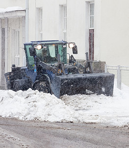 在降雪中清扫城市街道的除雪机