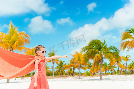 在热带海滩扮演超级英雄的小可爱女孩
