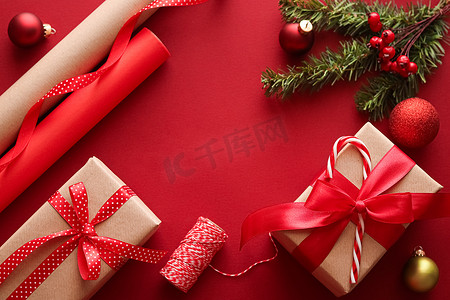圣诞节准备、节礼日和节假日送礼、圣诞牛皮纸和红色背景礼盒丝带作为包装工具和装饰品、DIY 礼物作为节日平铺