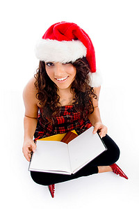 圣诞帽服装摄影照片_带圣诞帽和空白书的女性