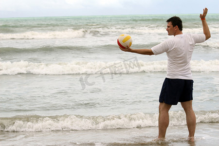 打排球的男人摄影照片_在沙滩上打排球的男人