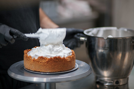 卫生事件摄影照片_糕点师设计师用抹刀在馅饼皮中填入柠檬味蛋白酥皮慕斯奶酪奶油