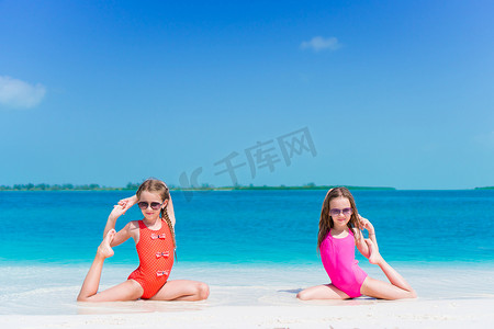 海滩小孩子摄影照片_快乐的小孩子在热带海滩的浅水区一起玩耍，玩得很开心。