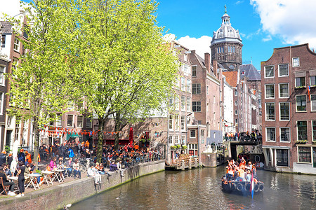 4 月 27 日：阿姆斯特丹运河上挤满了穿橙色衣服的船只和人们