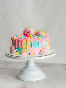白色背景上粉红色的 5 周年生日磨砂糖霜滴蛋糕