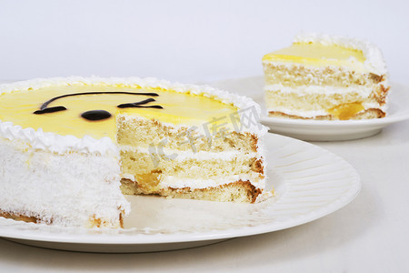 浅色背景桌上盘子上的黄色蛋糕