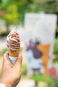 冰淇淋设计摄影照片_手里拿着巧克力冰淇淋