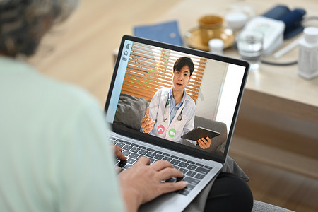 在老年妇女的肩膀上，医生通过视频电话在线咨询病人。