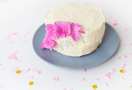 非常漂亮的白色小便当蛋糕，点缀着鲜花的粉色绣球花。