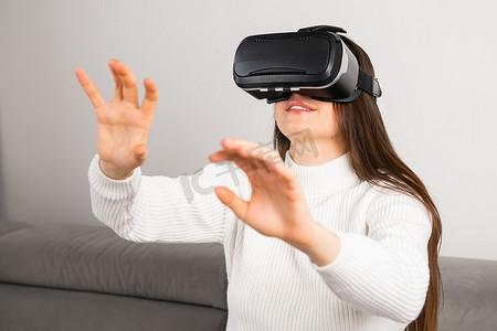 轻卡摄影照片_女人通过 VR 眼镜轻扫虚拟界面