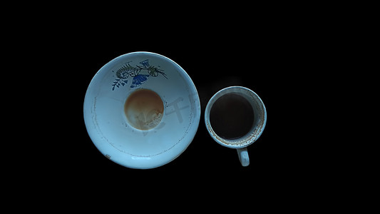 在黑色背景上隔离的空用过的茶杯的顶部镜头。