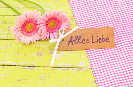 心愿卡摄影照片_美丽的粉红色花朵与木制背景上的爱情卡