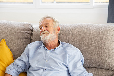 快乐的退休老人坐在沙发上微笑