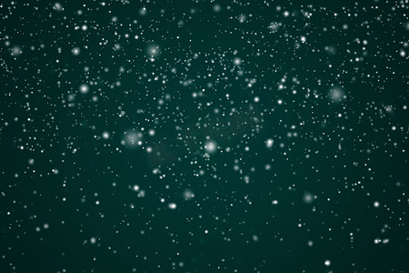 粒子飞散文字摄影照片_寒假和冬季背景、落在节日绿色背景上的白雪、雪花散景和降雪颗粒作为圣诞节和下雪假期设计的抽象下雪场景