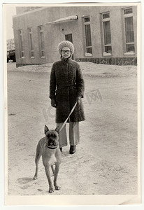 复古照片显示女人在遛狗。