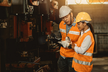 工程师团队男工与女工一起帮助支持重工业在工厂教学和培训机器操作
