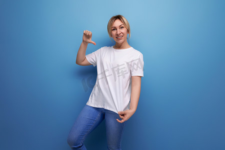 空白的女士衬衫摄影照片_金发年轻女士，带 T 恤模板，用于在带复制空间的工作室背景上插入商业信息