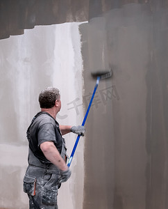 人用滚筒画墙。
