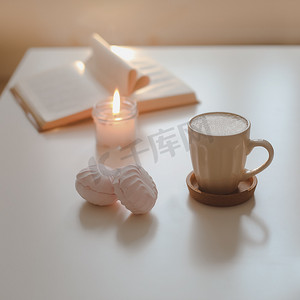 白桌背景顶视图上的咖啡杯、花、蜡烛和一本书