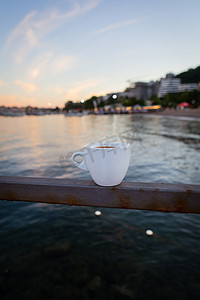 海边餐厅的露台，一杯白咖啡立在码头上。