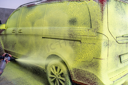 在车库里用绿色活性泡沫洗车