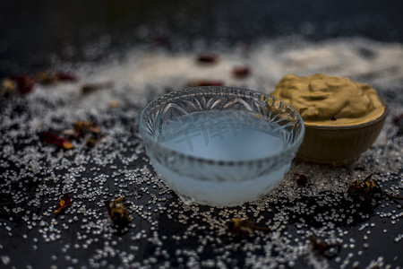 玻璃面摄影照片_Ubtan/面罩/木尔塔尼米蒂面膜或漂白土在玻璃碗中的木质表面，由木尔塔尼米蒂和椰子油组成，用于补救或治疗晒黑。在木质表面上。