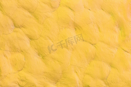 亮光背景摄影照片_石材表面墙体纹理抽象背景图案设计上的黄色亮光活力涂料