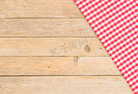 质朴的木桌背景上的红色方格桌布